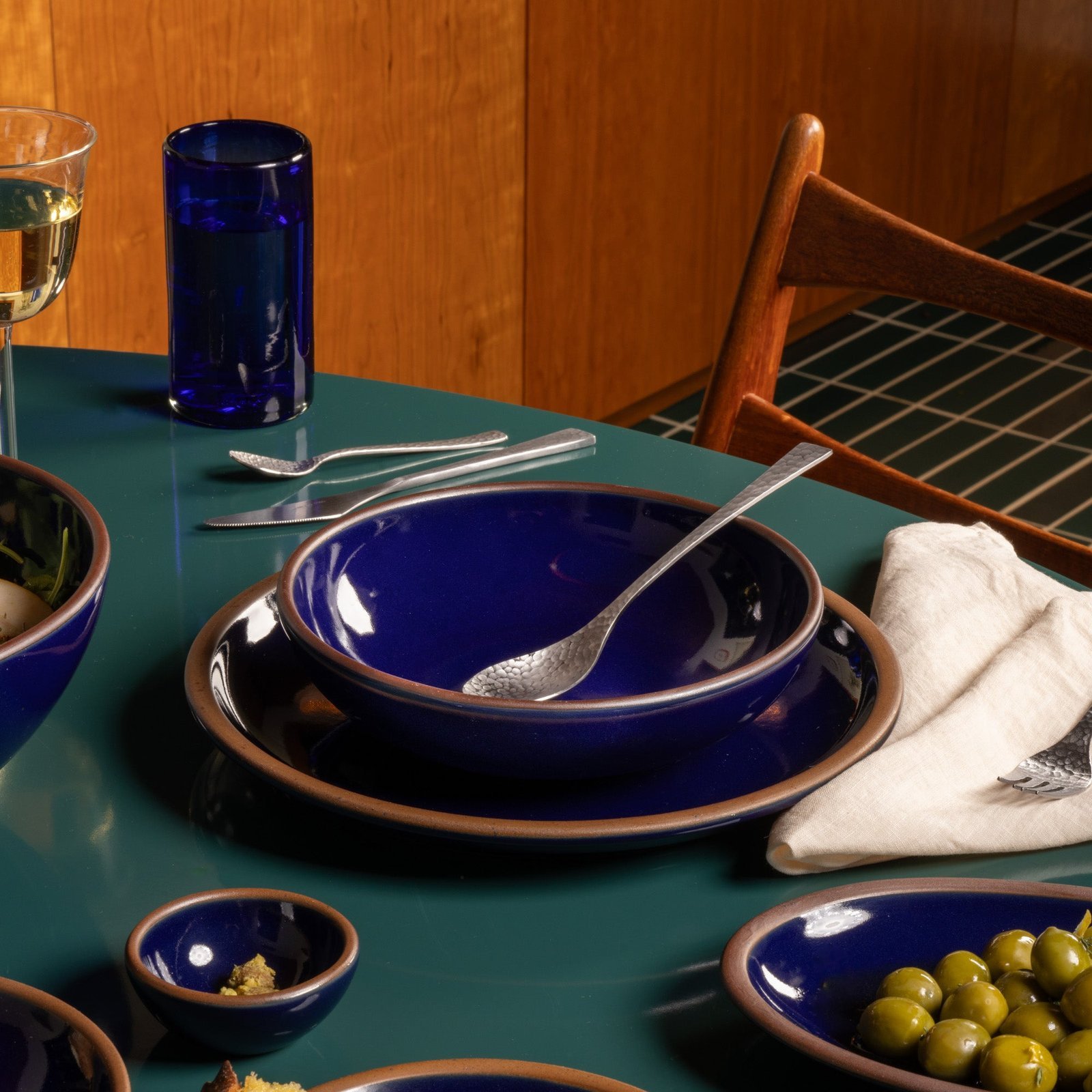 Verllage daily bowl in Midnight Navy, in a table setting with other dinnerware