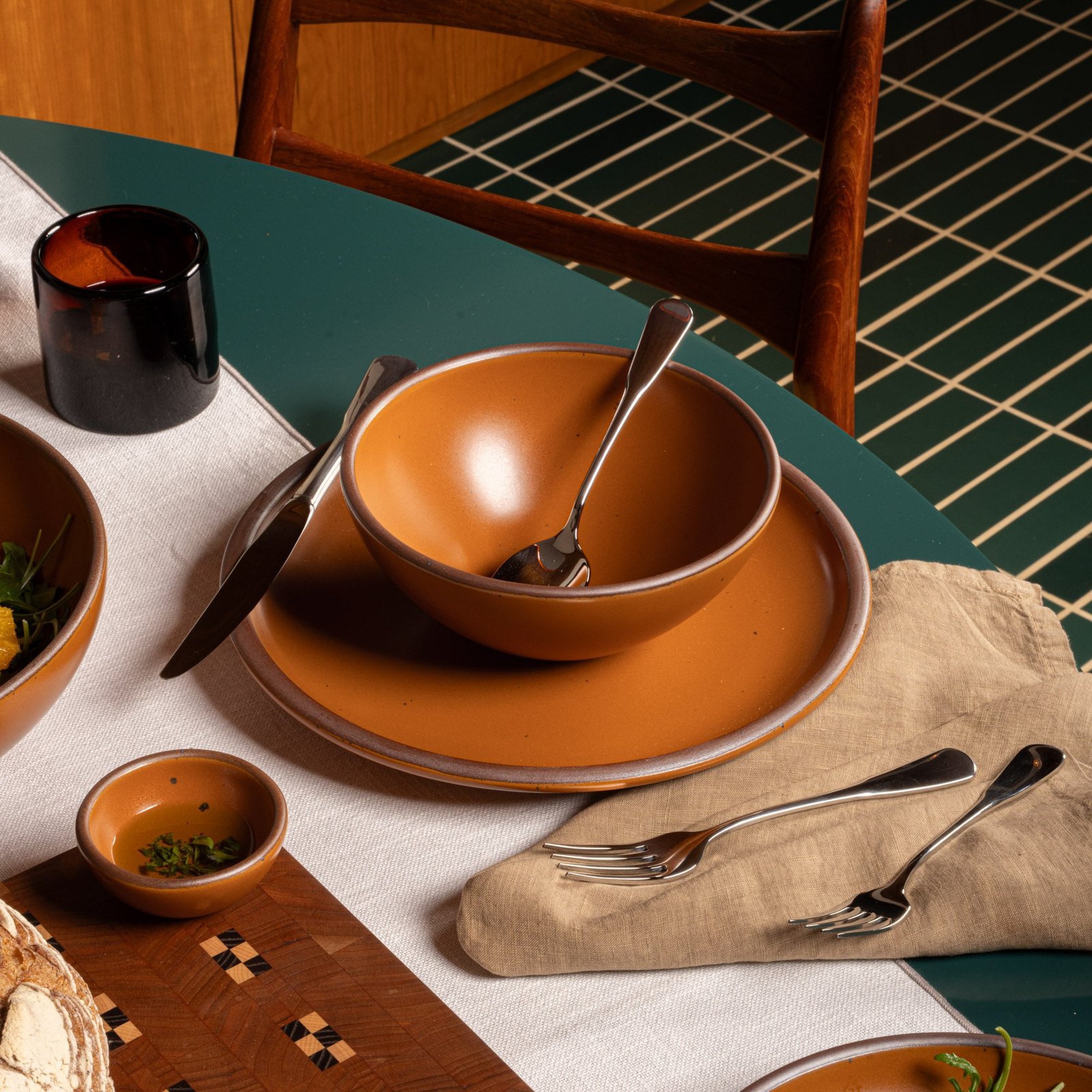 Verllage soup bowl in Ember, in a table setting with other dinnerware