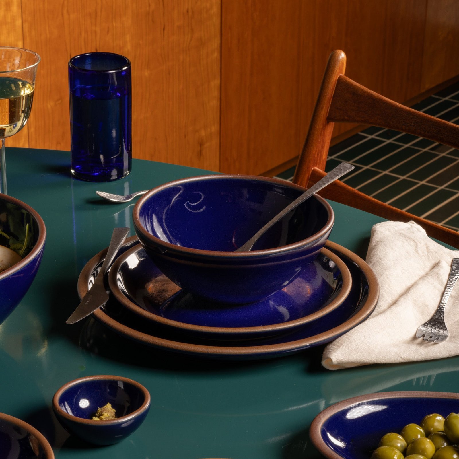 Verllage soup bowl in Midnight Navy, in a table setting with other dinnerware