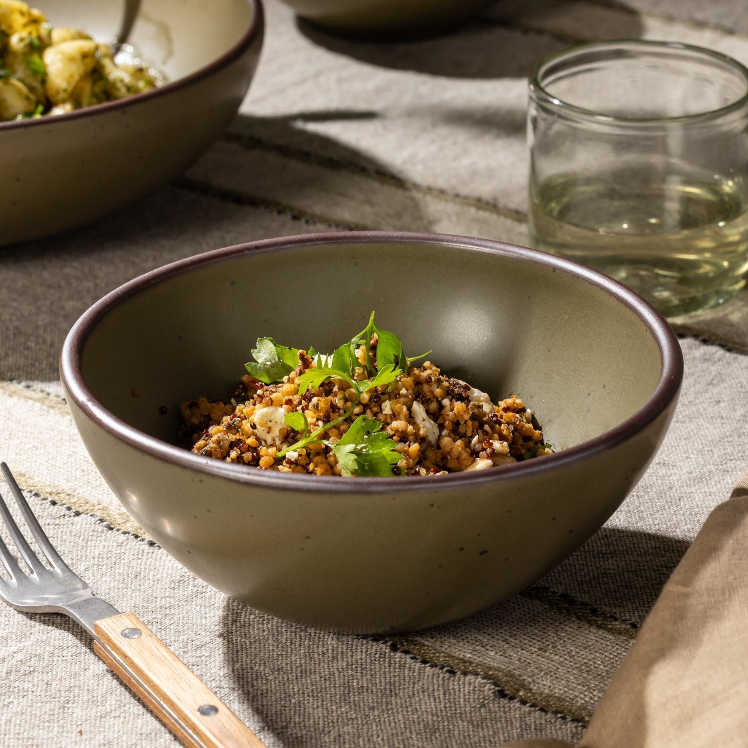 Verllage soup bowl in Pine Green, shown with a grain dish