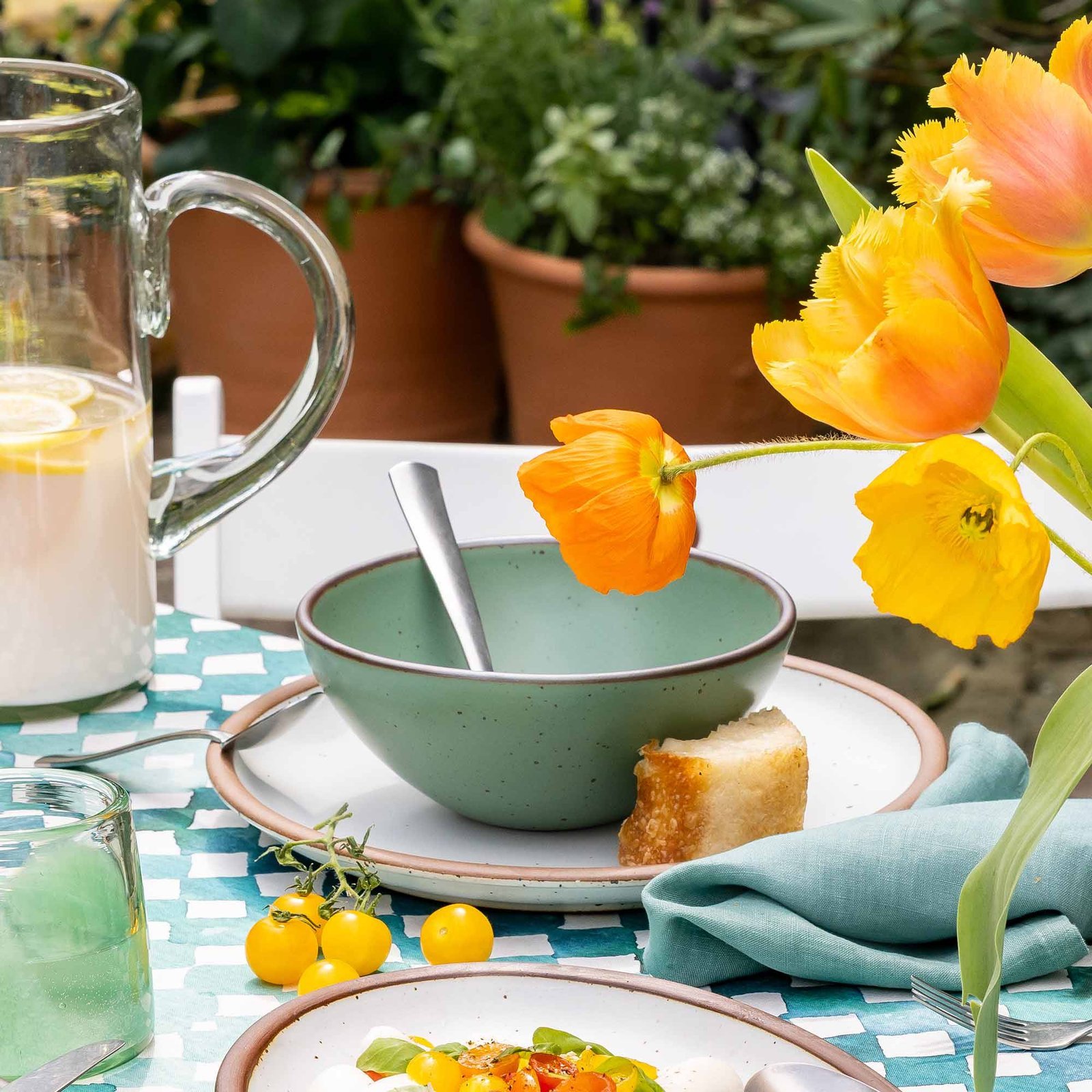 Verllage soup bowl in Viridian, in an outdoor table setting